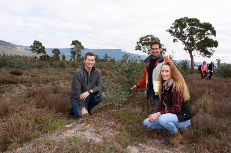 Lachlan Roberts, Gerard Leary and Heidi Bond from Hellyer College inspect a two year old tree at the Greening Australia Connorville restoration site