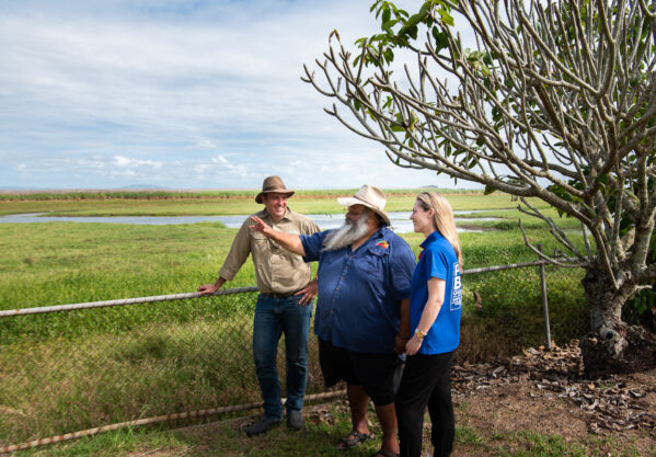 Director of Mungalla Station and Traditional Owner Jacob Cassady (wearing a cowboy style hat and dark blue polo shirt) stands between Greening Australia CEO Brendan Foran and Officeworks General Manager People Alexandra Staley.
